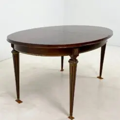 Ovalus išskleidžiamas raudonmedžio valgomojo stalas su žalvario apdailomis 106×171(+60)x77,5 cm