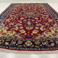 Margais augaliniais ornamentais raudoname fone dekoruotas persiškas rankų darbo kilimas Keshan
