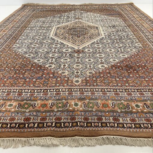 Persiškas šviesiai rudas rankų darbo kilimas iš vilnos dekoruotas augaliniais ir geometriniais ornamentais