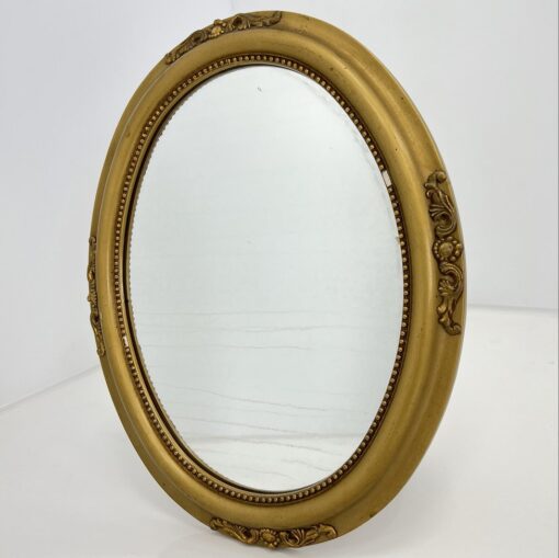 Veidrodis ovalo formos mediniu aukso spalvos rėmu su ornamentais