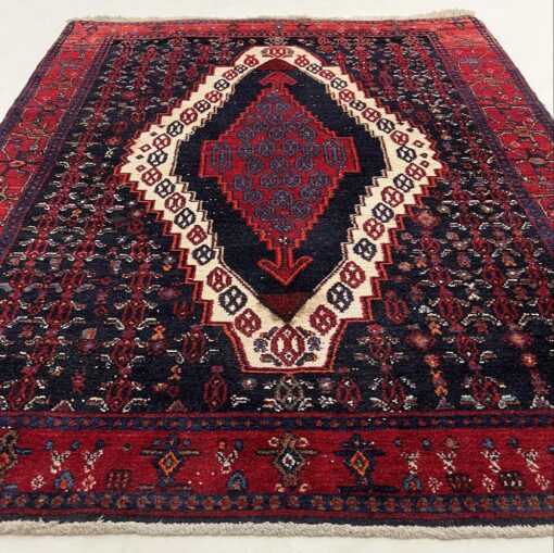 Persiškas raudonas rankų darbo kilimas su geometriniais ornamentais iš vilnos