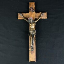 Ant sienos kabinamas medinis kryžius su varine Jėzaus skulptūra