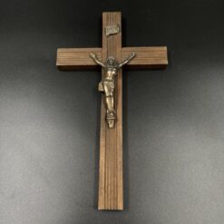 Ant sienos kabinamas medinis kryžius su metaline Jėzaus skulptūra