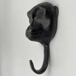 Metalinis sieninis kabliukas kabinti rūbams su beždžionės skulptūrėle.