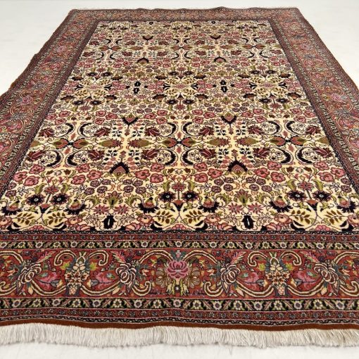 Rusvas persiškas vilnos rankų darbo kilimas su augaliniais ornamentais.