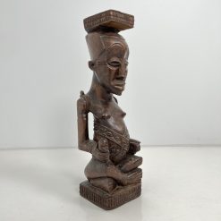 Sėdinčio vyriškio skulptūra iš medžio.