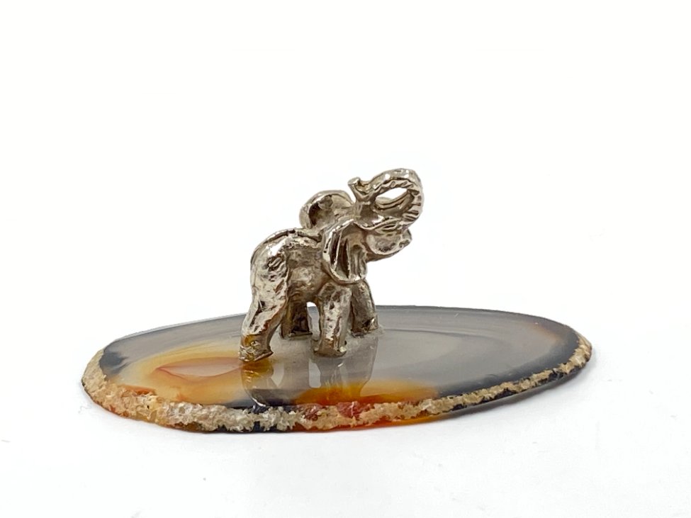 E0953-kitokios-skulpturos-2 Metalinė dramblio statula ant stiklinio padėklo 4×7,5×3 cm