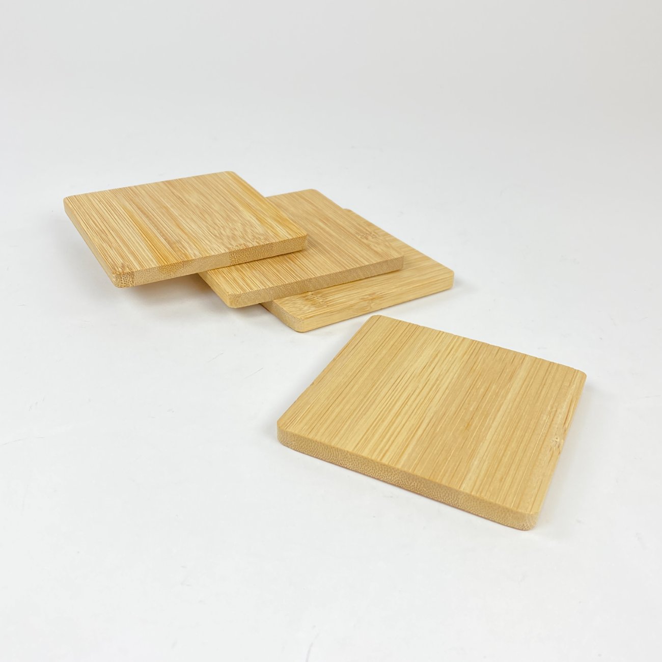 HN1184-lekstes-ir-serviravimo-padeklai-0 Kvadratiniai bambukiniai padėkliukai puodeliui 4 vnt. komplektas 10x10x1 cm