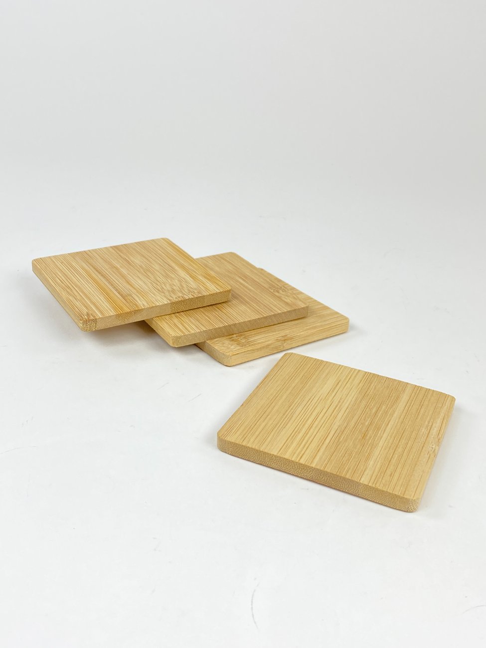 HN1184-lekstes-ir-serviravimo-padeklai-2 Kvadratiniai bambukiniai padėkliukai puodeliui 4 vnt. komplektas 10x10x1 cm