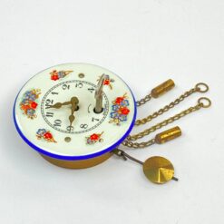 Mechaninis žalvario ir emaliuoto metalo miniatiūrinis sieninis laikrodis 4,5×6,5×12 cm