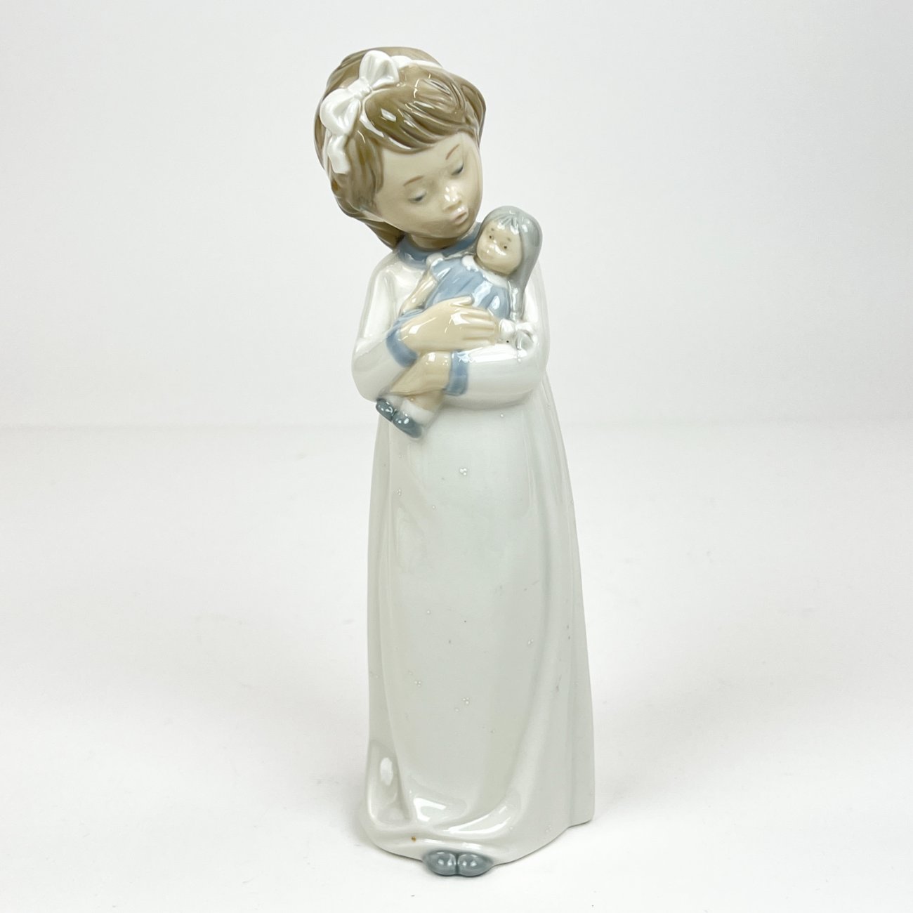 HK1293-porcelianines-skulpturos-0 Porcelianinė NAO by Lladró mergaitės su lėle statula Nr. 598 8x8x25 cm