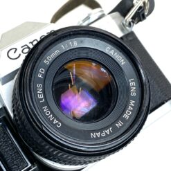 Vintažinis japoniškas Canon AE-1 juostinis fotoaparatas (neveikiantis) su Canon Lens FD 50 mm 1:18 objektyvu 8,5×14,5×9 cm