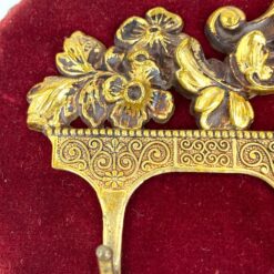 Sieninė kabykla aptraukta raudonu veliūru su žalvariniais ornamentais ir šešiais kabliukais 3x28x16 cm