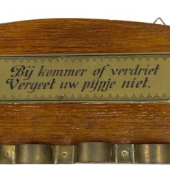 Ąžuolinė sieninė pypkių kabykla su pypke ir užrašu: „Bij kommer of verdriet, vergeet uw pyjpje niet” 3x28x12 cm
